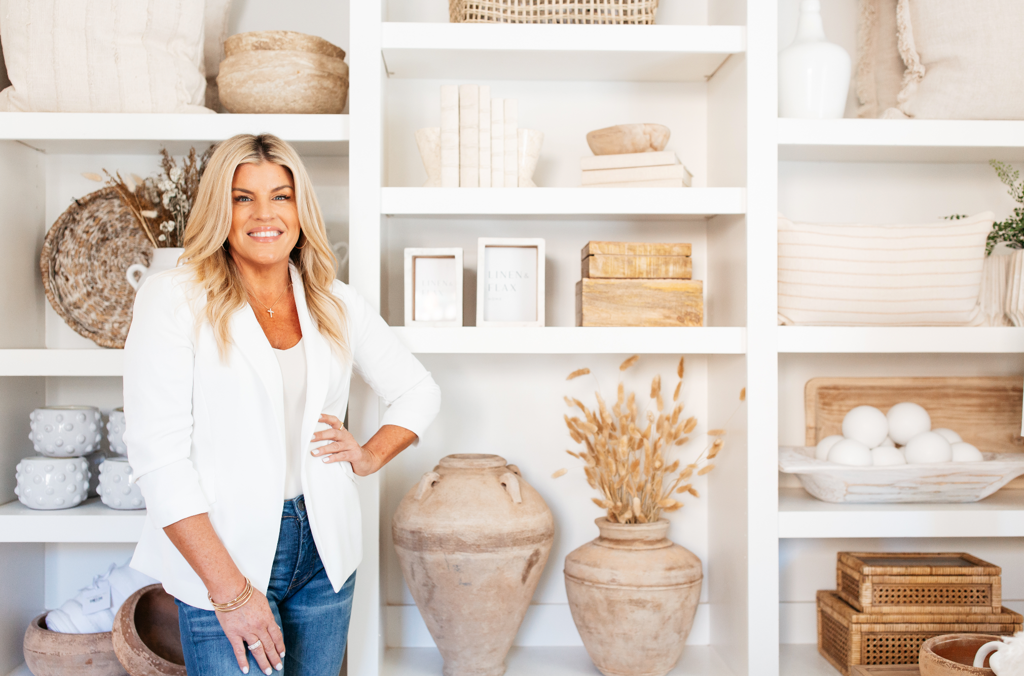 Photo of Chaz Easterly posing in front of white designer furniture with decorative elements by Linen & Flax Co.
